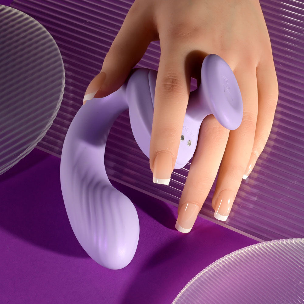 Playboy Pleasure REV ME UP -  USB Rechargeable Dual Motor Curved Vibrator held in hand against a vibrant background.