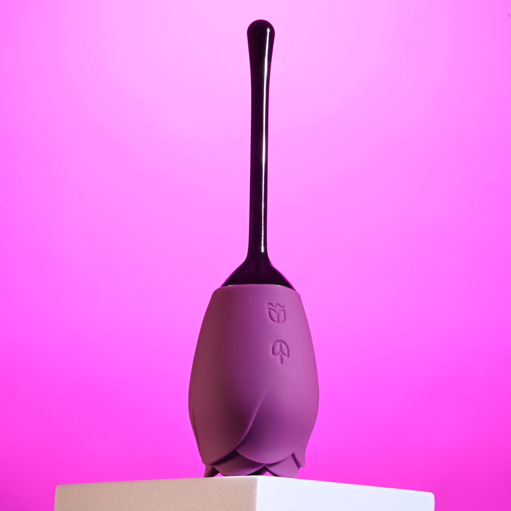 Playboy Pleasure PETAL -  USB Rechargeable Flicking Stimulator in purple against a pink backdrop.