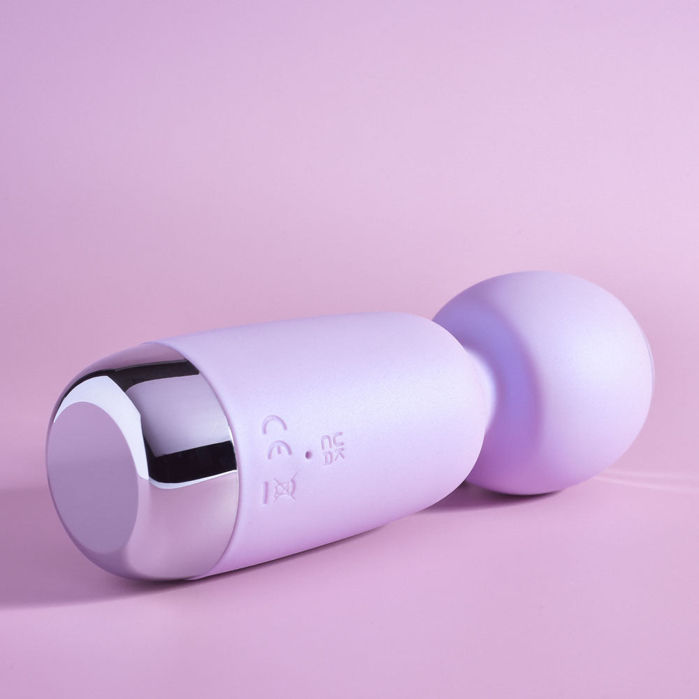Playboy Pleasure ROYAL MINI - Lilac 12.5 cm USB Rechargeable Mini Wand Vibrator on a pink background.
