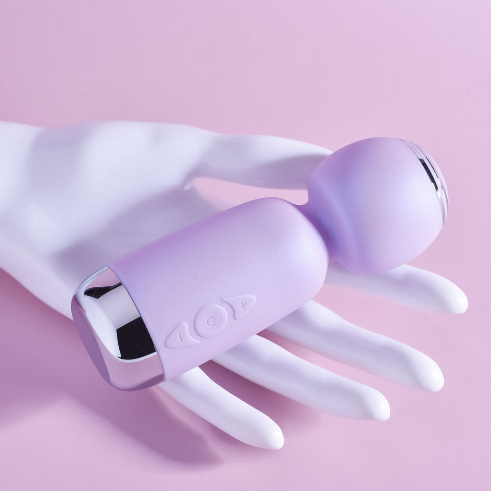 Playboy Pleasure ROYAL MINI - Lilac 12.5 cm USB Rechargeable Mini Wand Vibrator on a hand, showcasing its sleek design.