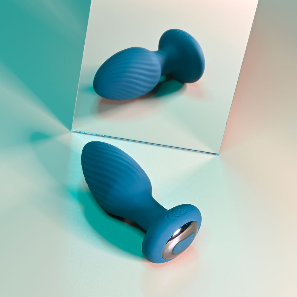 Playboy Pleasure SPINNING TAIL TEASER -  9.7 cm USB Rechargeable Vibrating & Rotating Butt Plug with Wireless Remote on a reflective surface.