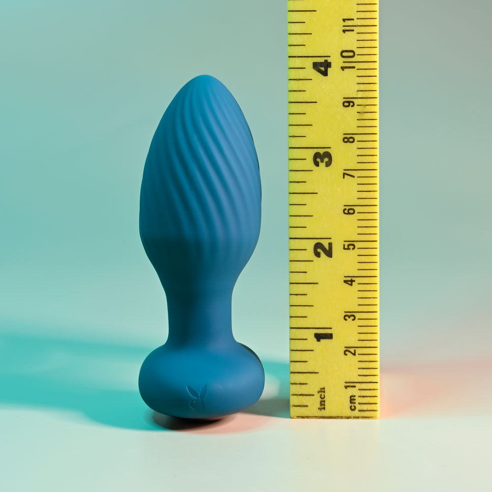 Playboy Pleasure SPINNING TAIL TEASER - 9.7 cm USB Rechargeable Vibrating & Rotating Butt Plug with Wireless Remote displayed with a ruler.