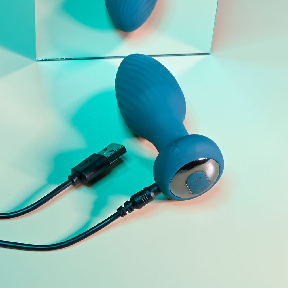 Playboy Pleasure SPINNING TAIL TEASER -  9.7 cm USB Rechargeable Vibrating & Rotating Butt Plug with Wireless Remote on a colorful surface.