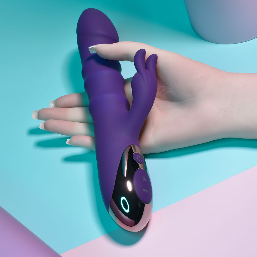 Playboy Pleasure HOP TO IT - 23.5 cm USB Rechargeable Rabbit Vibrator held in hand with a smooth purple silicone design.