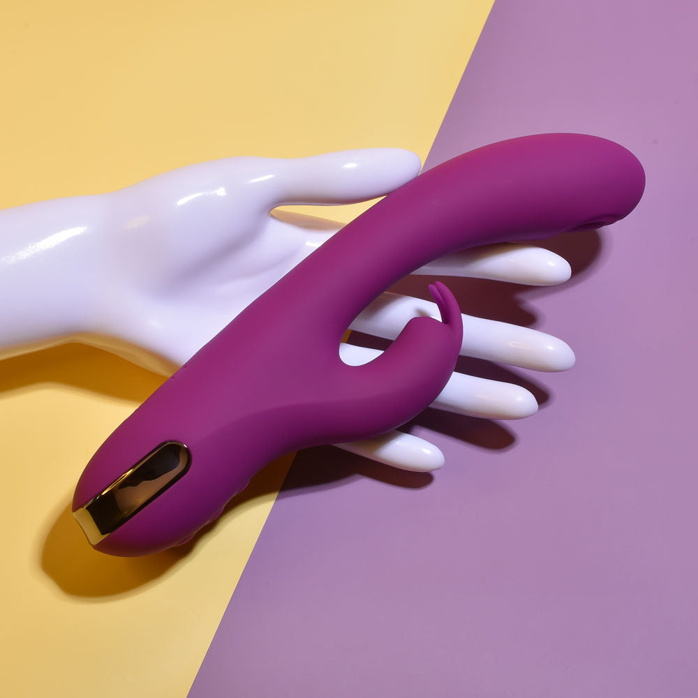 Playboy Pleasure THUMPER - 21.9 cm USB Rechargeable Rabbit Vibrator displayed on a hand against a colorful background.