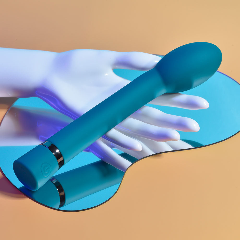 Playboy Pleasure ON THE SPOT - 21.6 cm USB Rechargeable G-Spot Vibrator on a mirror with a hand.