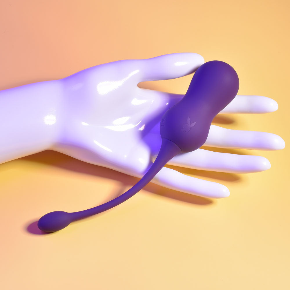 Playboy Pleasure DOUBLE TIME -  USB Rechargeable Vibrating Kegel Balls on a hand, showcasing its unique double-bulb design.