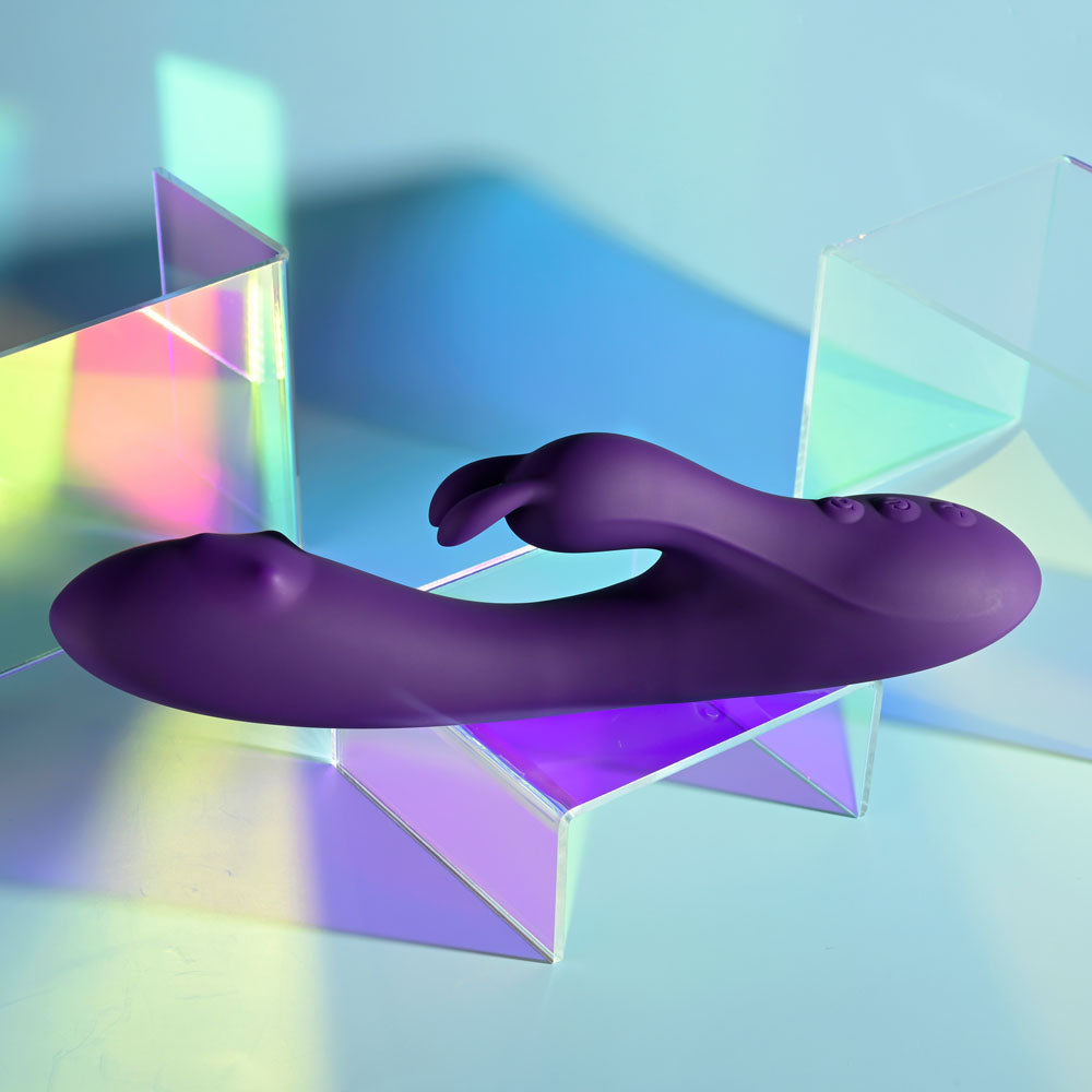 Playboy Pleasure ON REPEAT - 19.7 cm USB Rechargeable Rabbit Vibrator displayed with colorful light reflections.