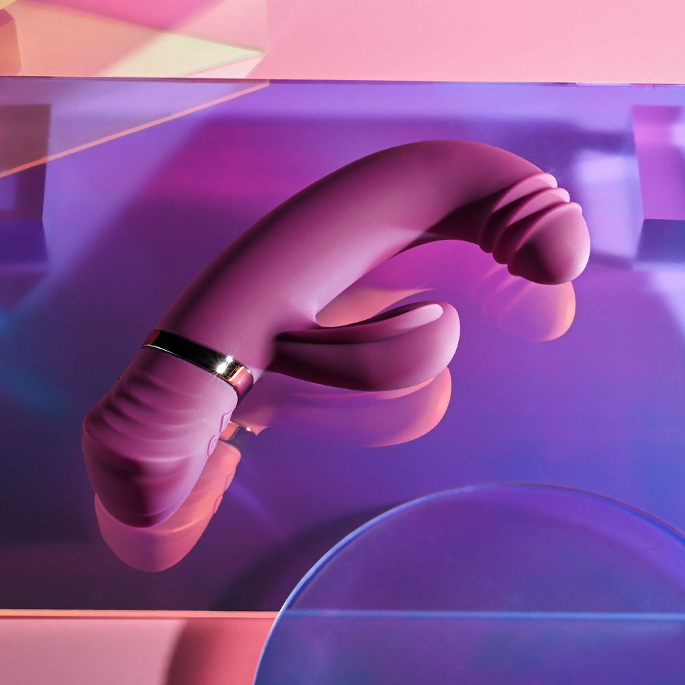 Playboy Pleasure TAP THAT - 16.5 cm USB Rechargebale Rabbit Vibrator on a colorful abstract background.