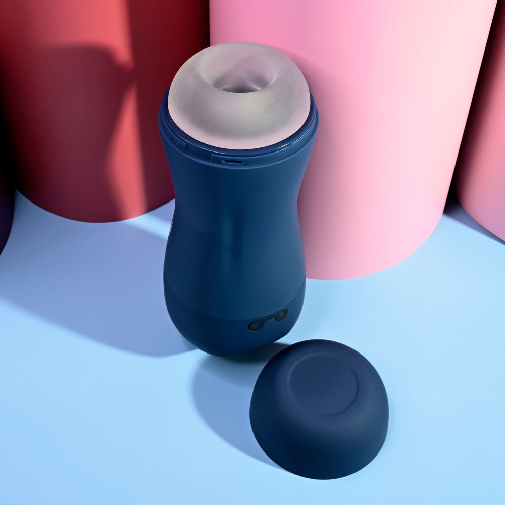 Playboy Pleasure GUSTO - USB Rechargeable Vibrating & Sucking Masturbator on a colorful background with removable cap.