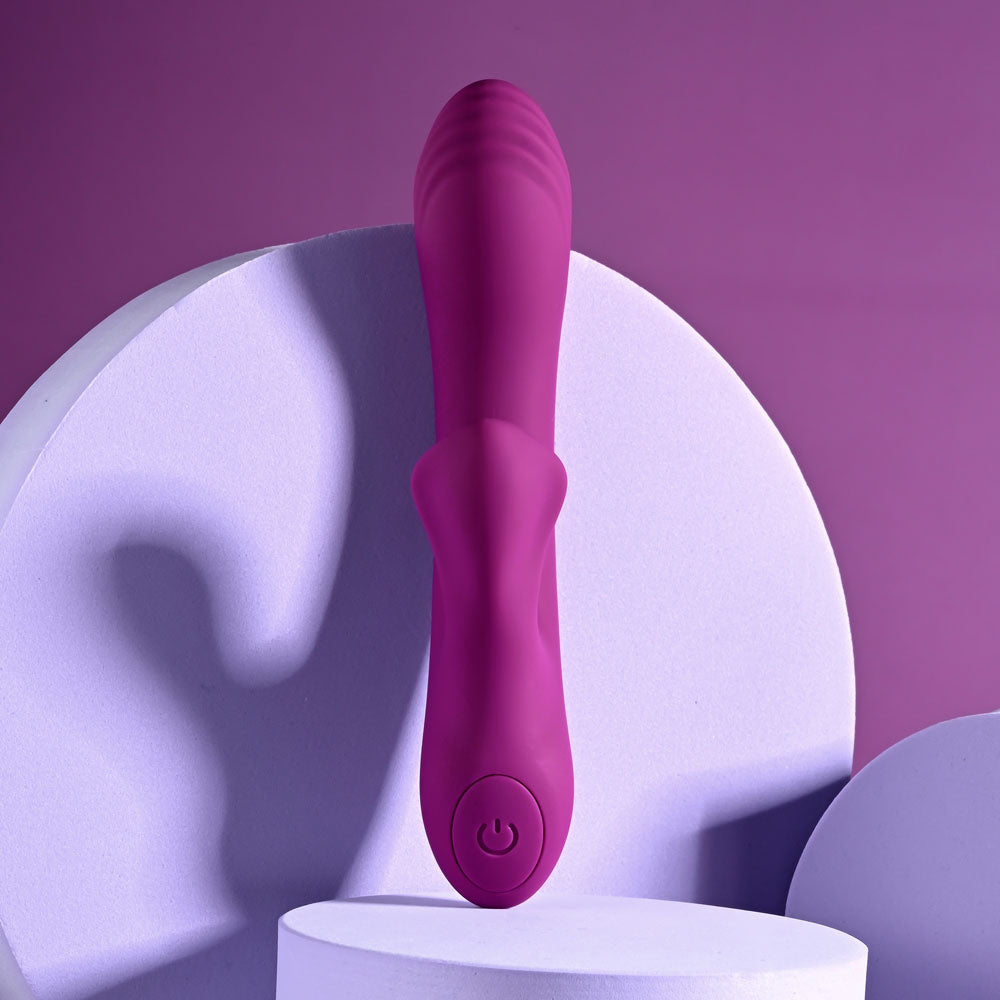 Playboy Pleasure BITTY BUNNY - 14.7 cm USB Rechargeable Rabbit Vibrator in vibrant purple resting on smooth surfaces.
