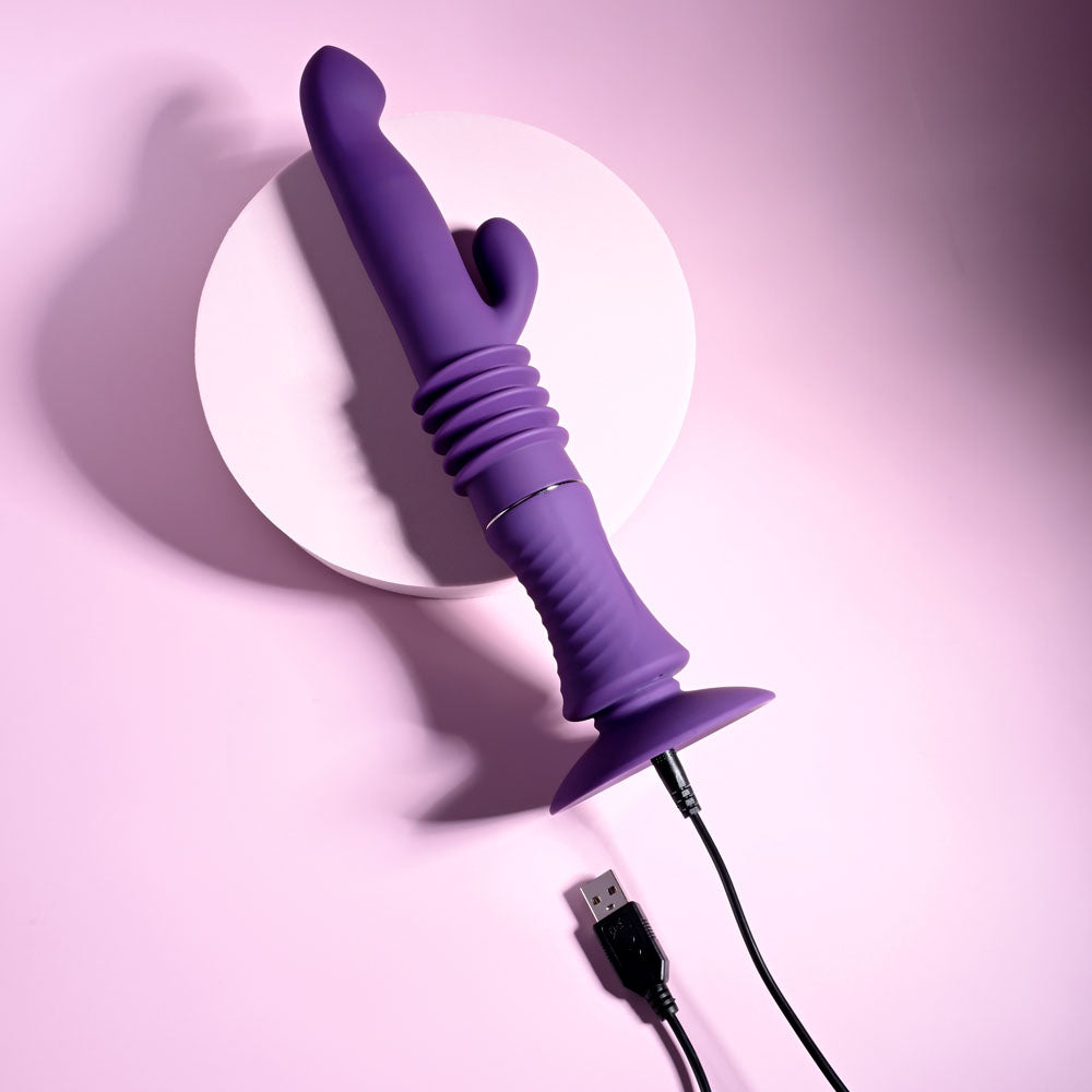 Playboy Pleasure HOPPY ENDING - 29.2 cm USB Rechargeable Thrusting Rabbit Vibrator on a pink background.