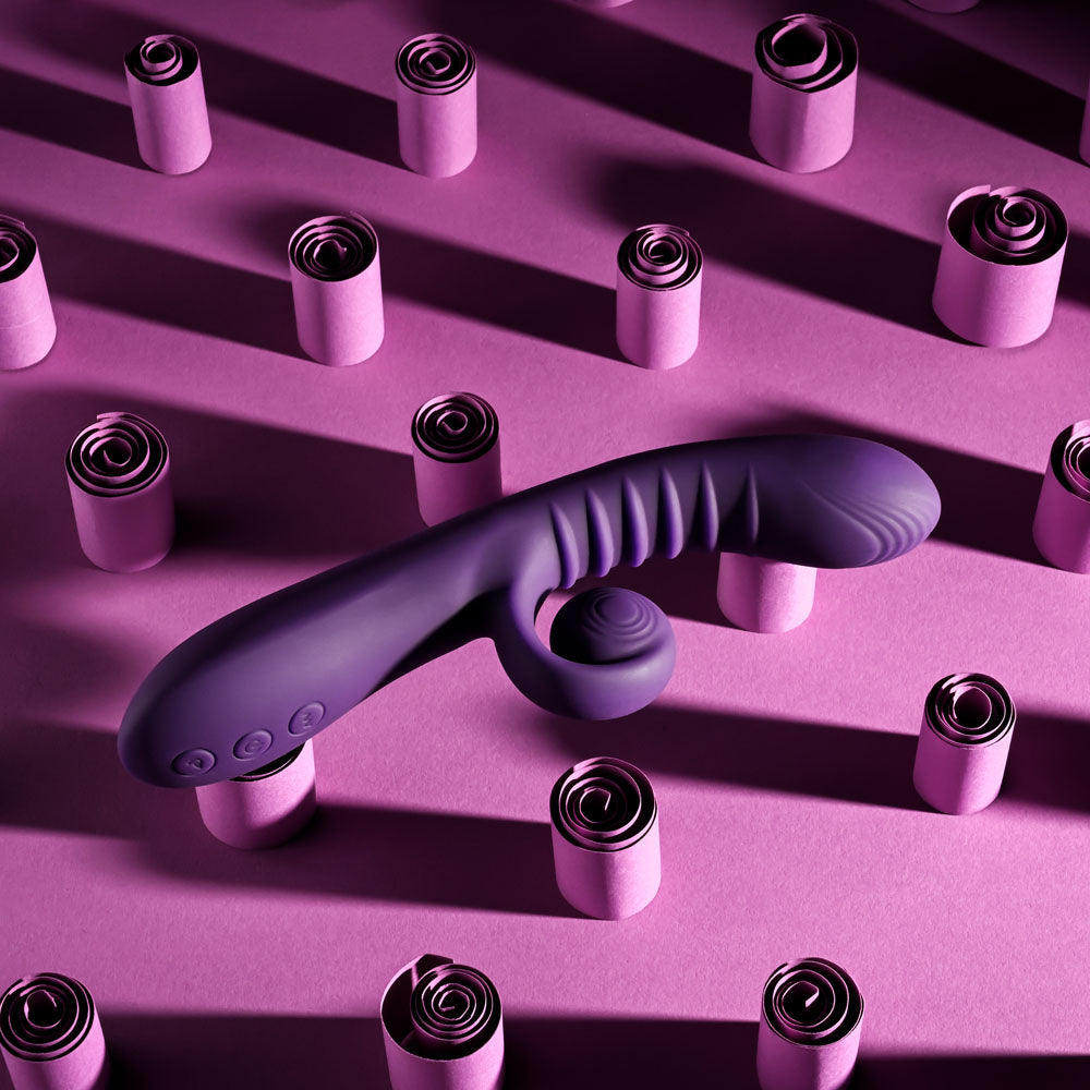 Playboy CURLICUE -  23.5 cm USB Rechargeable Rabbit Vibrator on a purple background with curls.