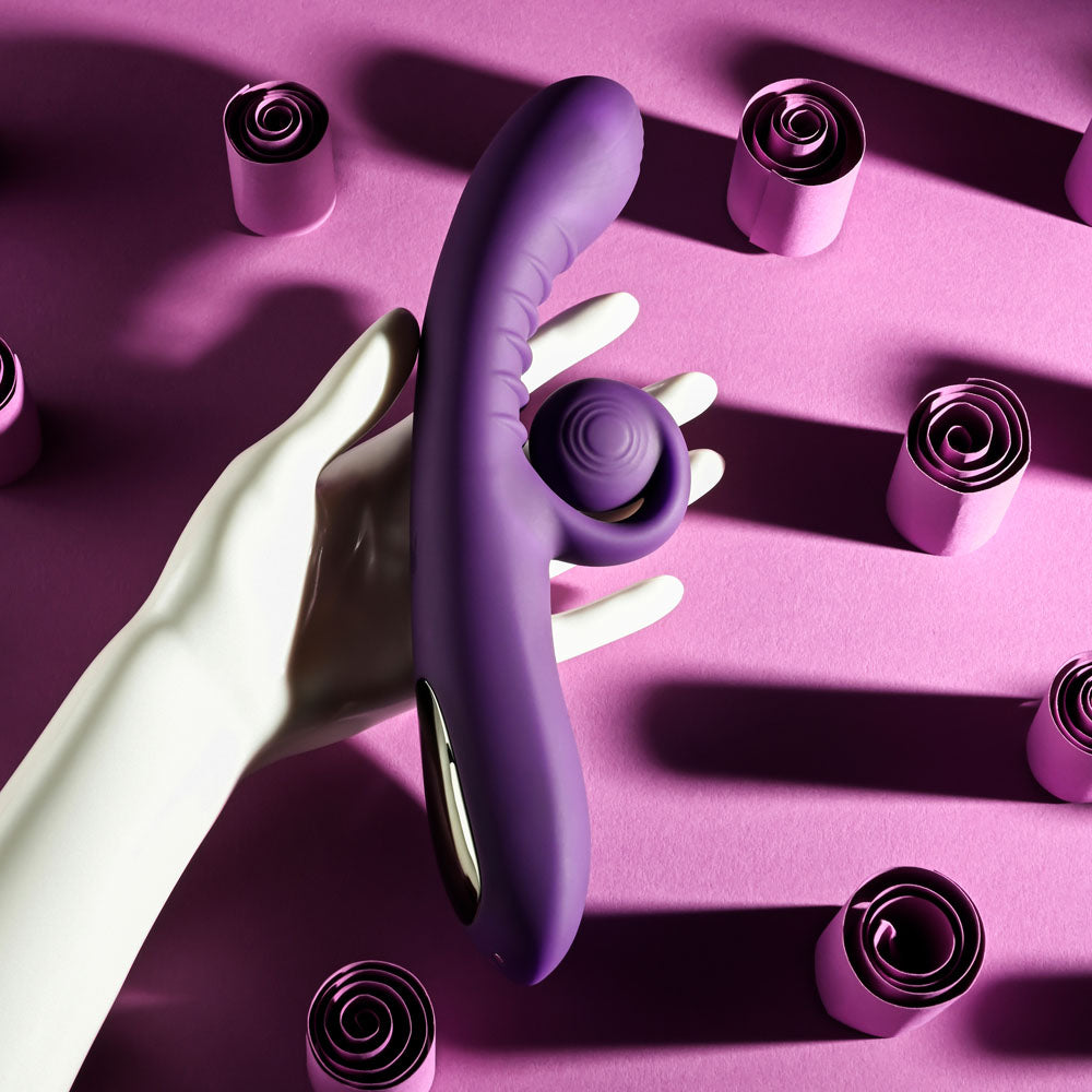 Playboy CURLICUE - 23.5 cm USB Rechargeable Rabbit Vibrator on a pink background with rolled paper decorations.