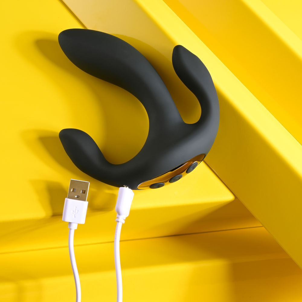Playboy Pleasure TRIPLE THREAT -  USB Rechargeable Triple Probe Vibrator charging on a bright yellow surface.