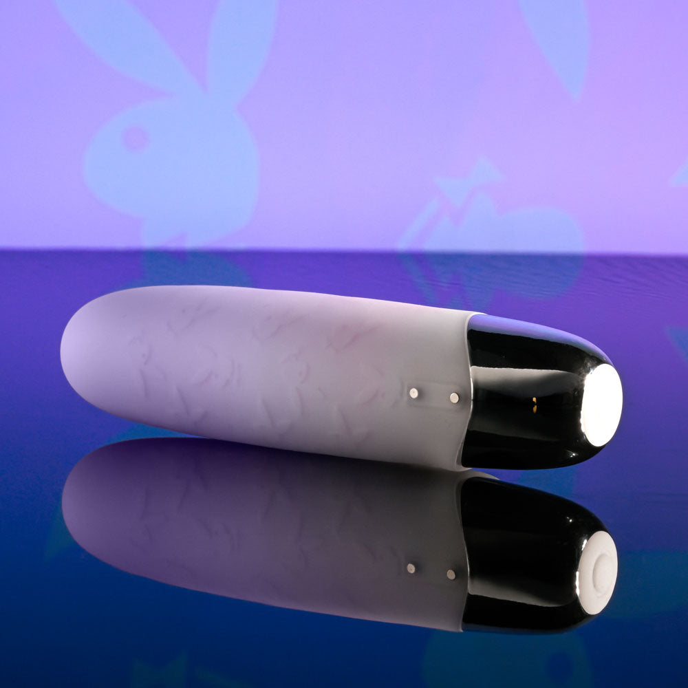 Playboy Pleasure BUNNY BUNCH - Pearl 11.3 cm USB Rechargeable Bullet on a reflective surface with bunny design background.