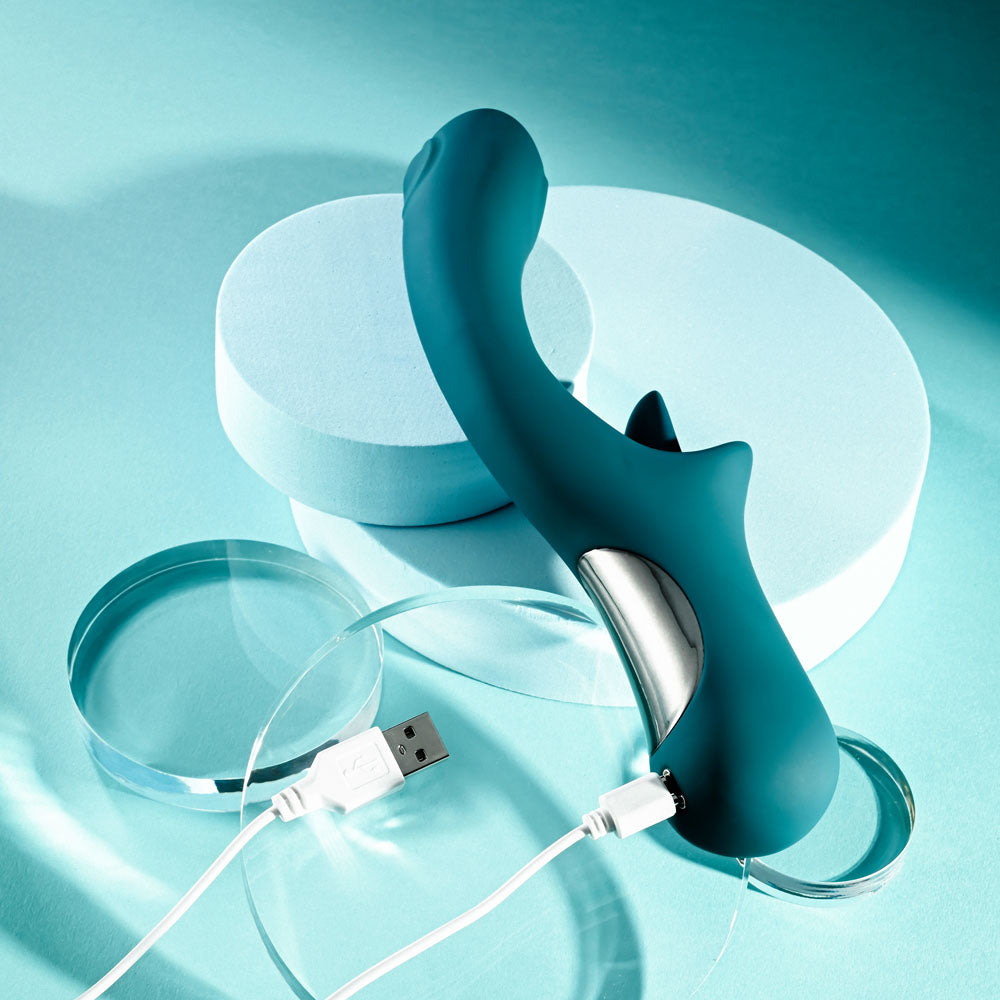 Playboy Pleasure HARMONY - 22.9 cm USB Rechargeable Vibrator with Clitoral Flicker on a teal background with charging cable.