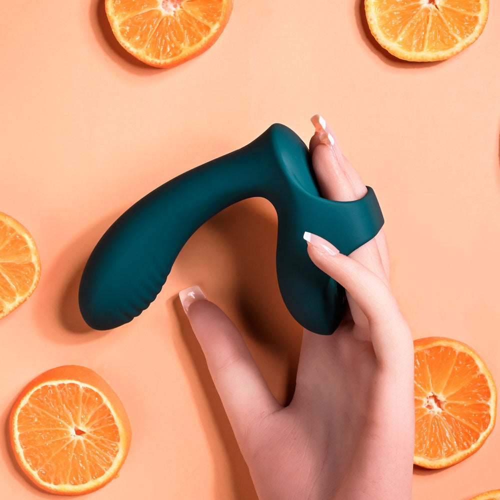 Playboy Pleasure WRAPPED AROUND YOUR FINGER -  USB Rechargeable Finger Stimulator surrounded by orange slices.