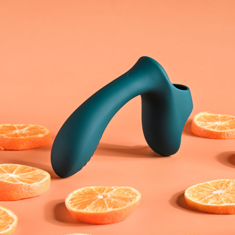 Playboy Pleasure WRAPPED AROUND YOUR FINGER -  USB Rechargeable Finger Stimulator among orange slices.