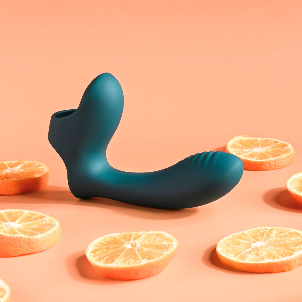 Playboy Pleasure WRAPPED AROUND YOUR FINGER - USB Rechargeable Finger Stimulator surrounded by orange slices.