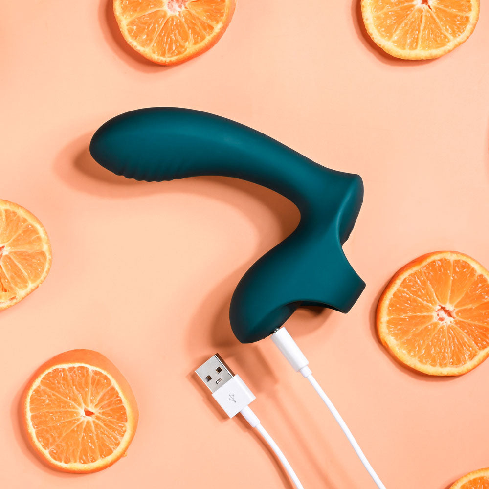 Playboy Pleasure WRAPPED AROUND YOUR FINGER -  USB Rechargeable Finger Stimulator surrounded by sliced oranges.