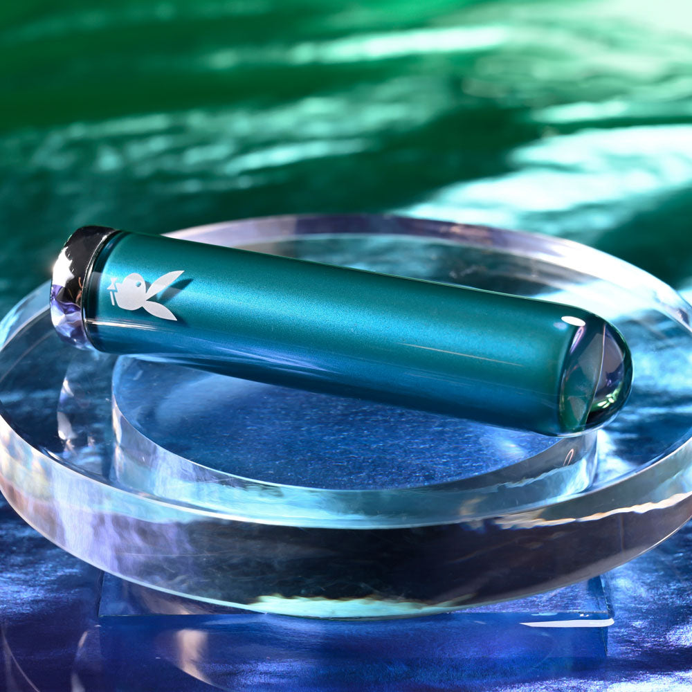 Playboy Pleasure EMERALD -  9.1 cm USB Rechargeable Glass Tipped Bullet on a crystal plate with a sleek design.