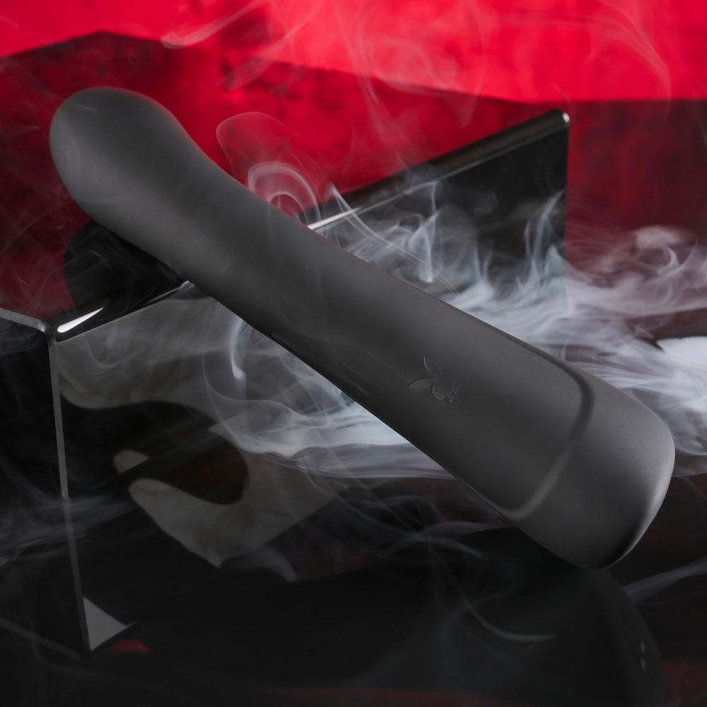 Playboy Pleasure THATS THE SPOT -  23.3 cm USB Rechargeable Rabbit Vibrator with G-Spot Tapper on a black surface with smoke.