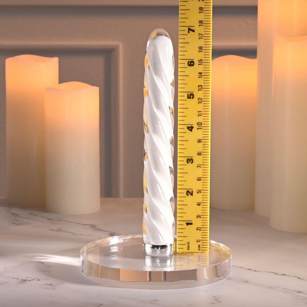 Playboy Pleasure IN A TWIST - Glass 17.5 cm USB Rechargeable Vibrator on a display with candles.