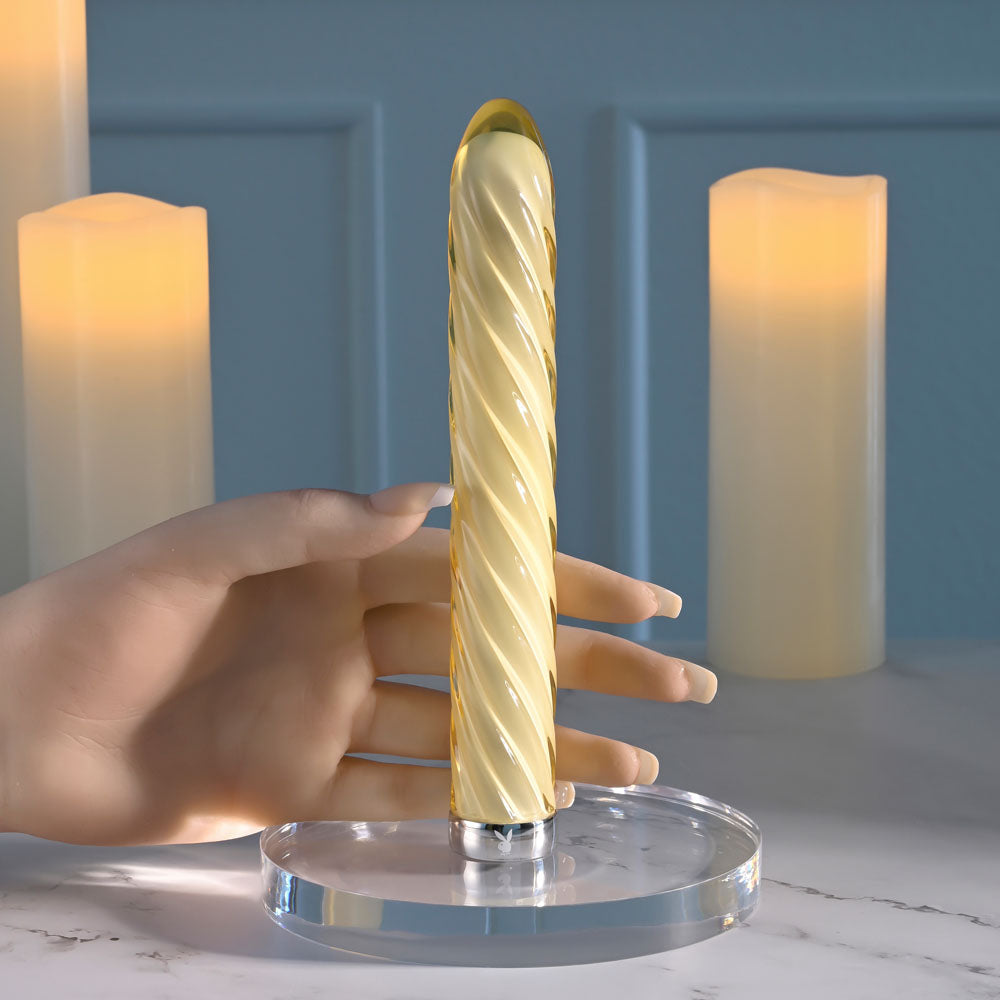 Playboy Pleasure TWIST OF FATE USB rechargeable glass vibrator with swirling design on display.