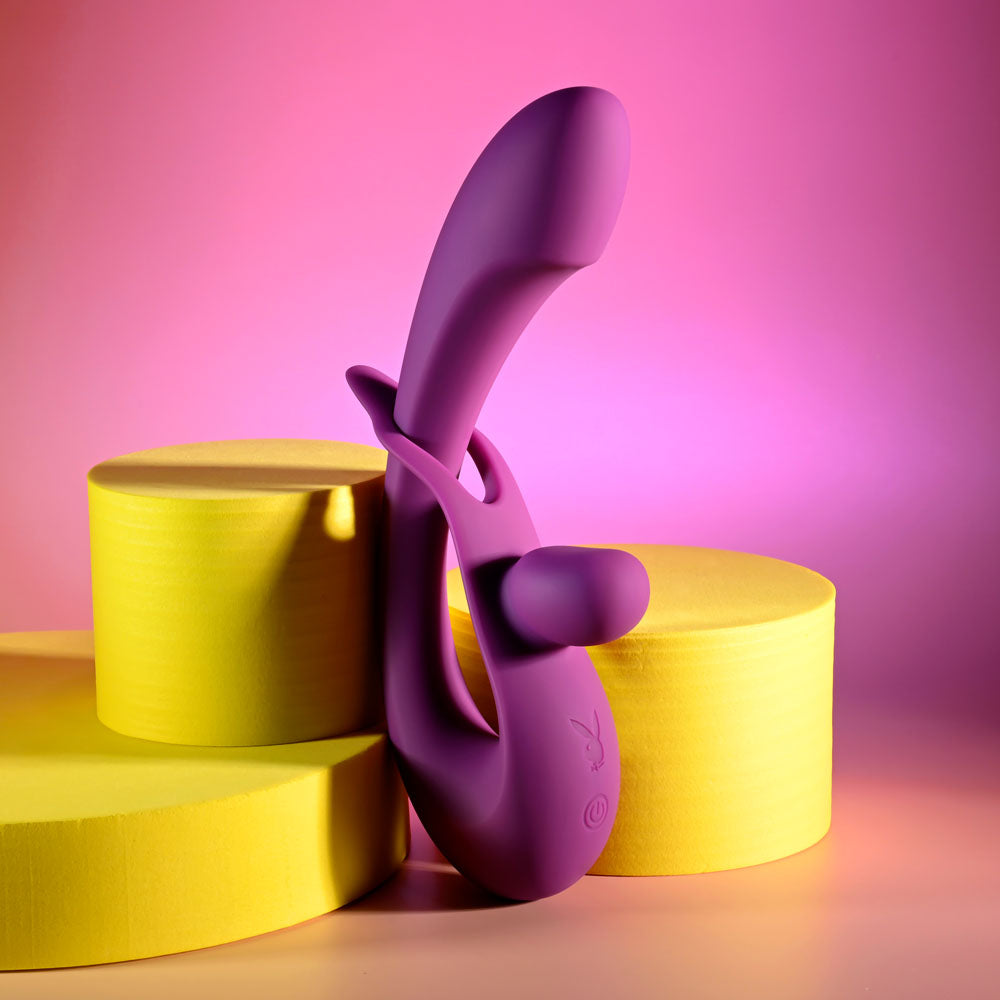 Playboy Pleasure CHA CHA SLIDE -  20 cm USB Rechargeable Rabbit Vibrator on colorful geometric background.
