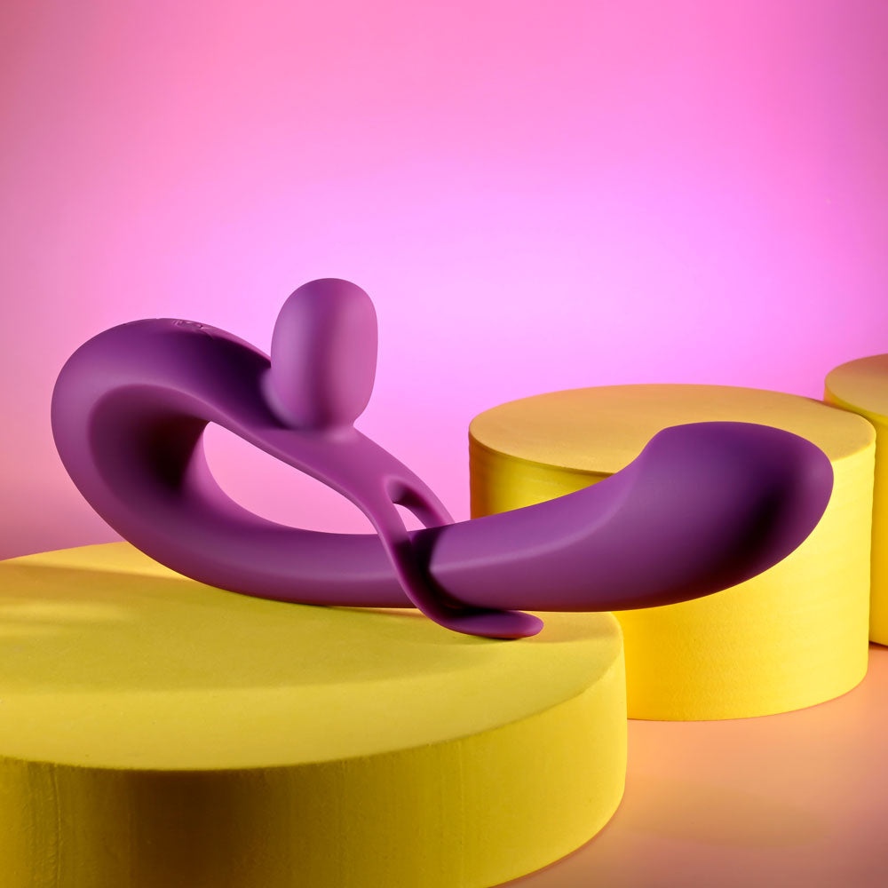 Playboy Pleasure CHA CHA SLIDE -  20 cm USB Rechargeable Rabbit Vibrator on vibrant platforms against a pink background.