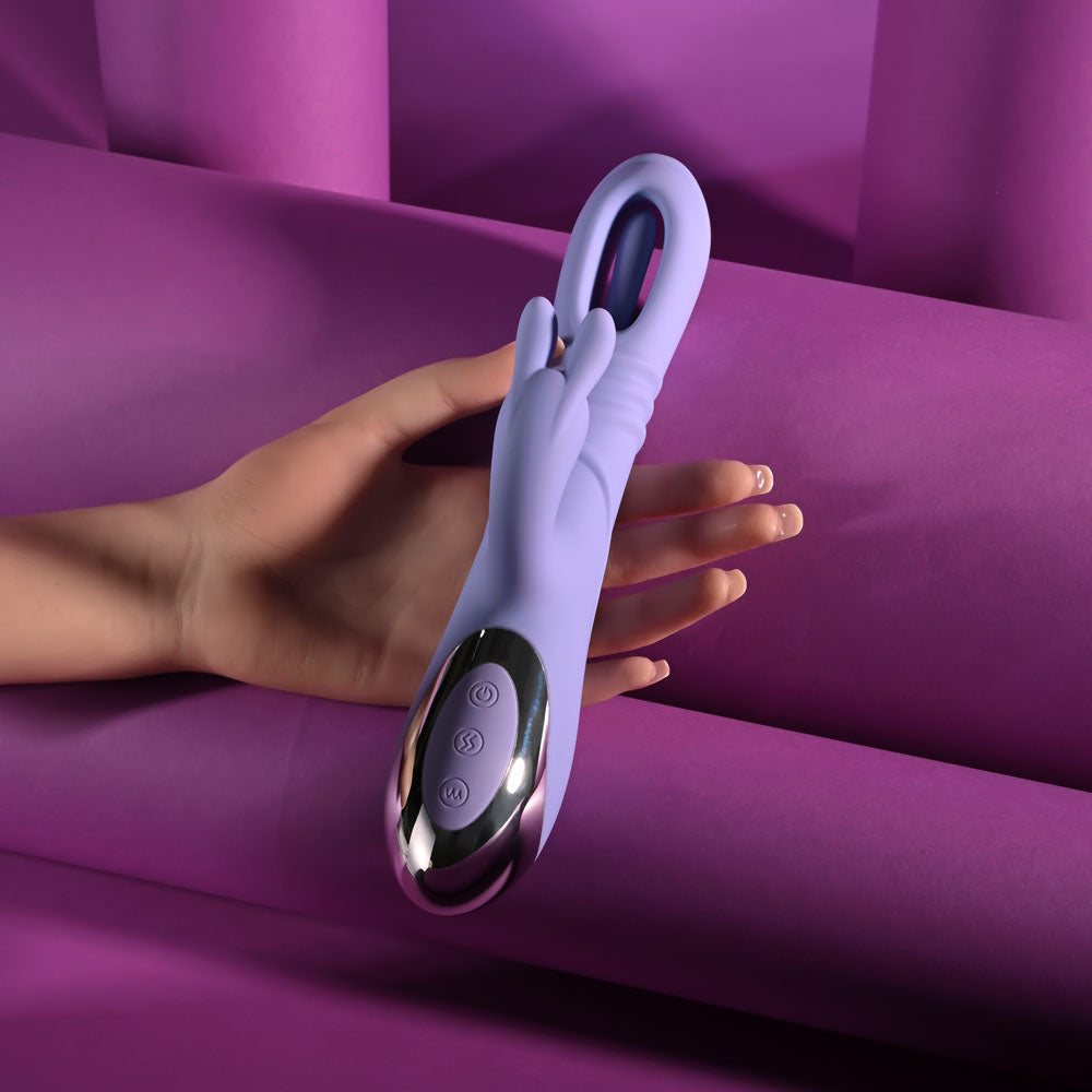 USB rechargeable rabbit vibrator showcased in a hand against a vibrant purple background with textured materials.