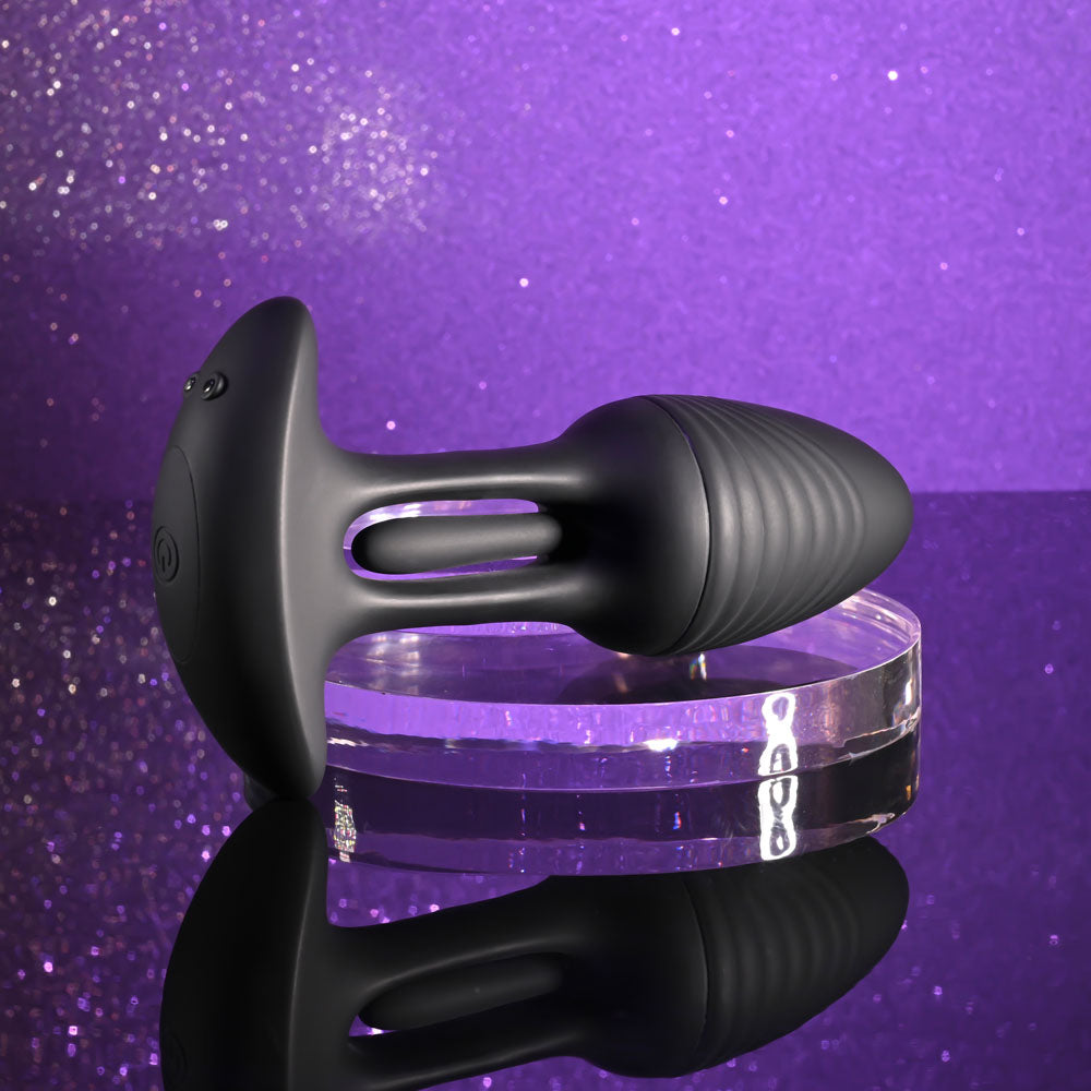 Playboy Pleasure RIM SHOT - 11.4 cm USB Rechargeable Vibrating Butt Plug on a reflective surface with a purple glitter background.