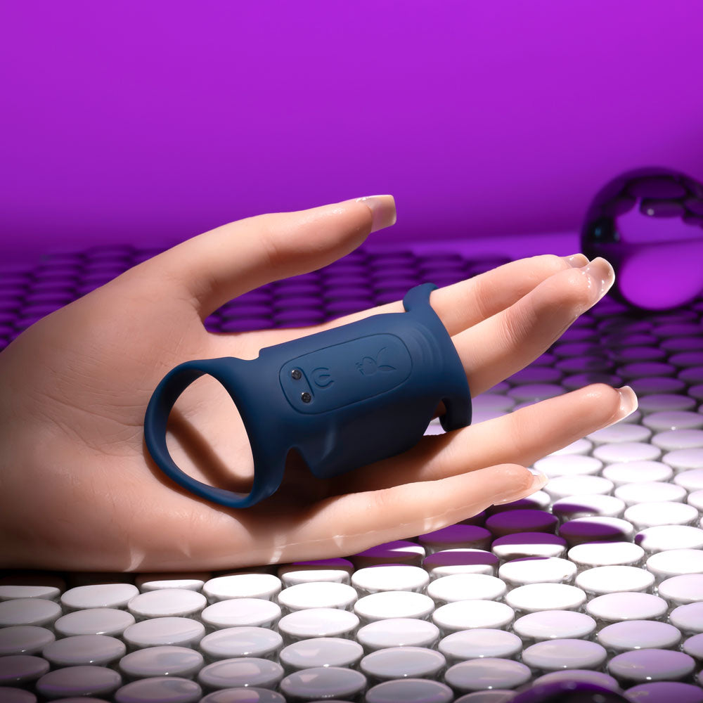 Playboy Pleasure JET PACK - Dark USB rechargeable vibrating penis harness on a hand, showcasing its design and features.