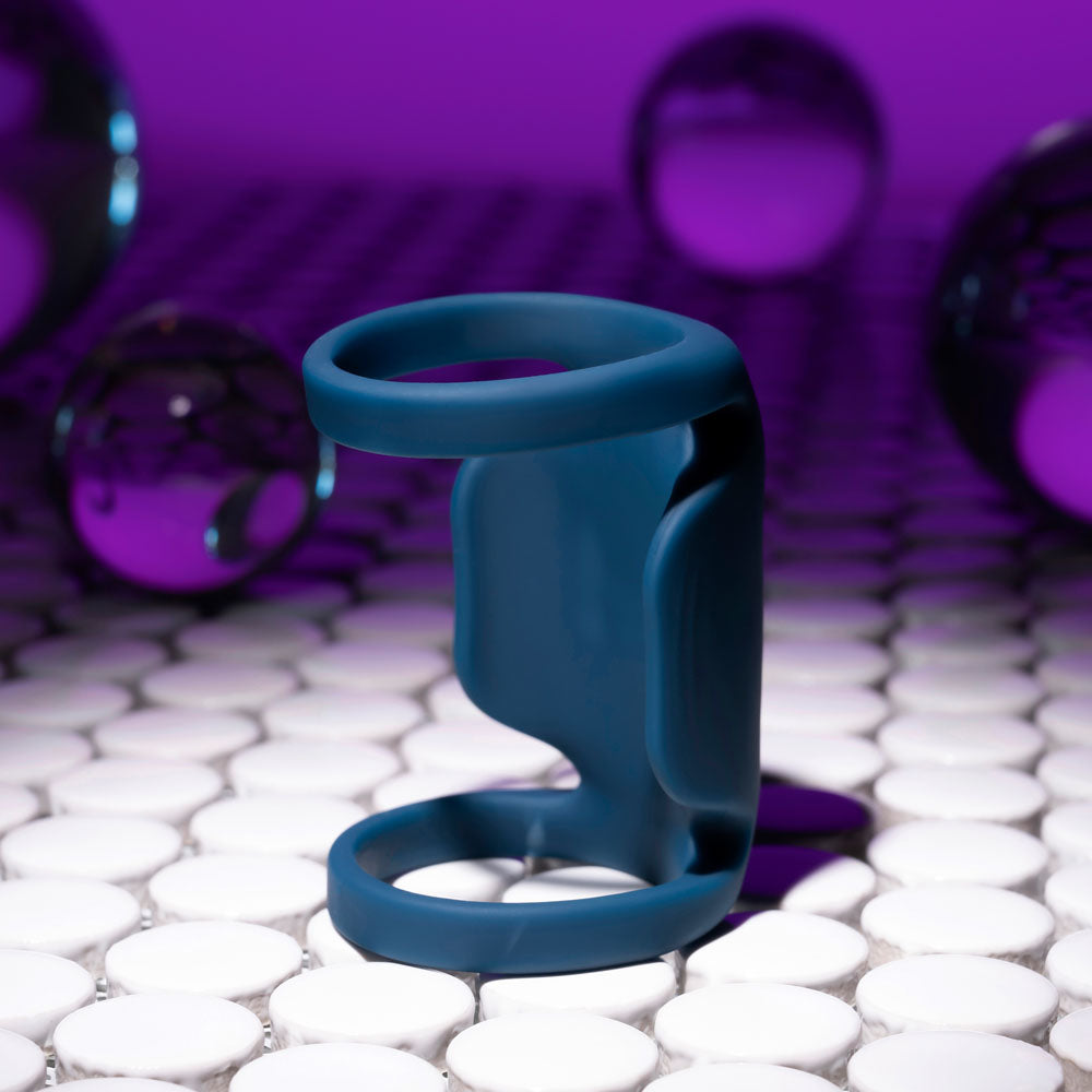 Playboy Pleasure JET PACK - Dark USB rechargeable vibrating penis harness on tile with colorful background.