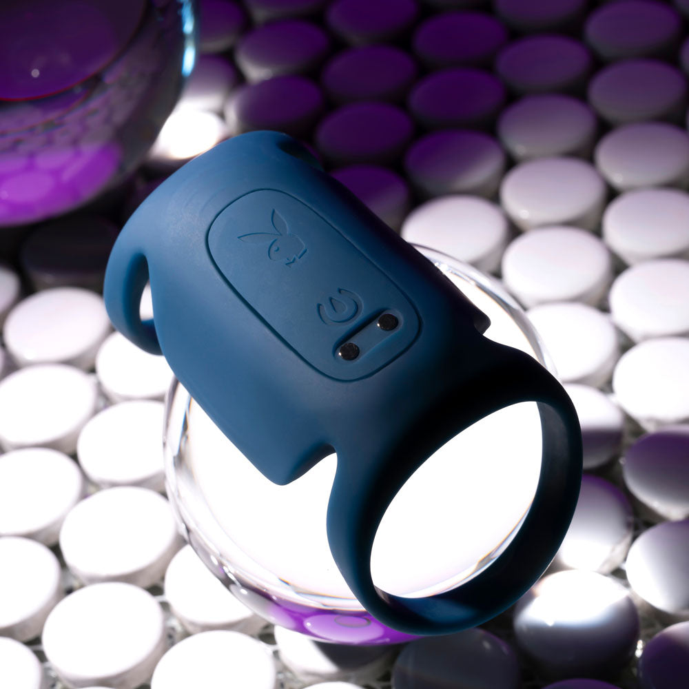 Playboy Pleasure JET PACK - Dark USB Rechargeable Vibrating Penis Harness on a reflective surface.