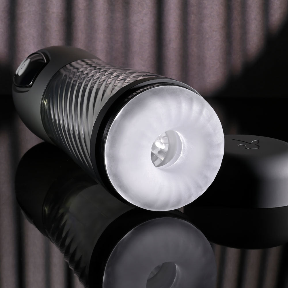 Playboy Pleasure WHIRLWIND - USB Rechargeable Thrusting and Spinning Auto Stroker on a reflective surface.