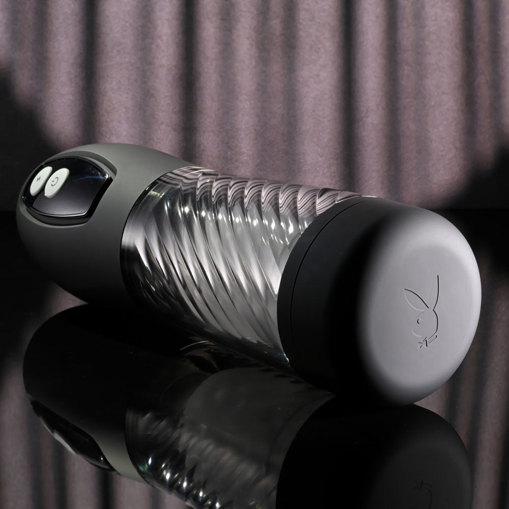 Playboy Pleasure WHIRLWIND - USB Rechargeable Thrusting and Spinning Auto Stroker on a reflective surface.