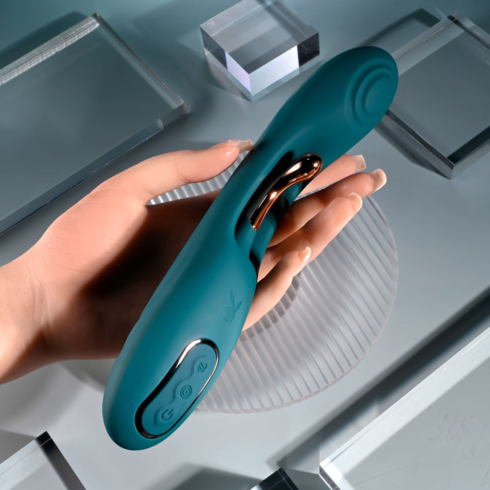 Playboy Pleasure AURELIE - 22.7 cm USB Rechargeable Vibrator with Internal Flicker in hand on a modern surface.
