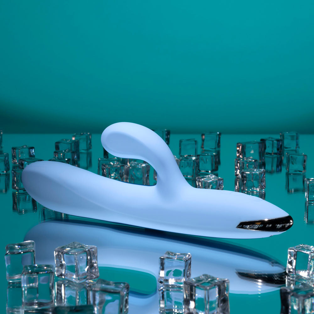 Playboy Pleasure USB rechargeable rabbit vibrator on a reflective surface surrounded by ice cubes.