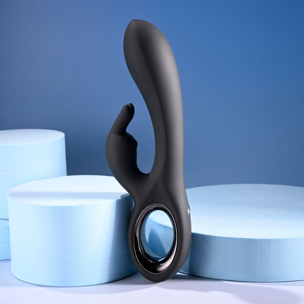USB rechargeable rabbit vibrator displayed against a blue background with soft foam circles.