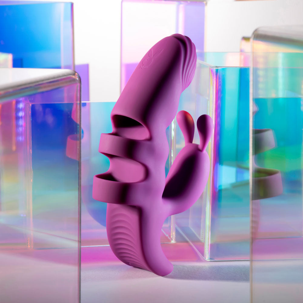 Playboy Pleasure LEND A HAND - USB Rechargeable Finger Vibrator displayed among colorful transparent blocks.