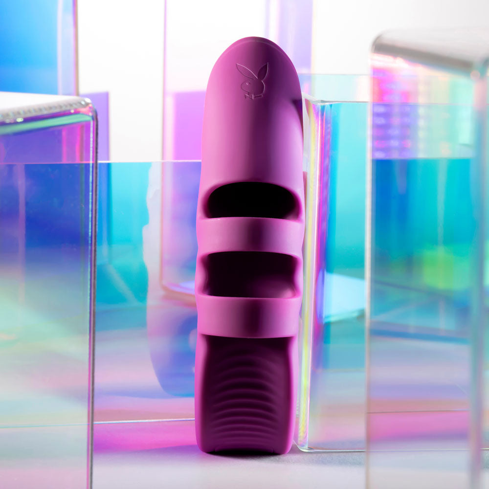 Playboy Pleasure LEND A HAND - USB Rechargeable Finger Vibrator surrounded by colorful translucent blocks.