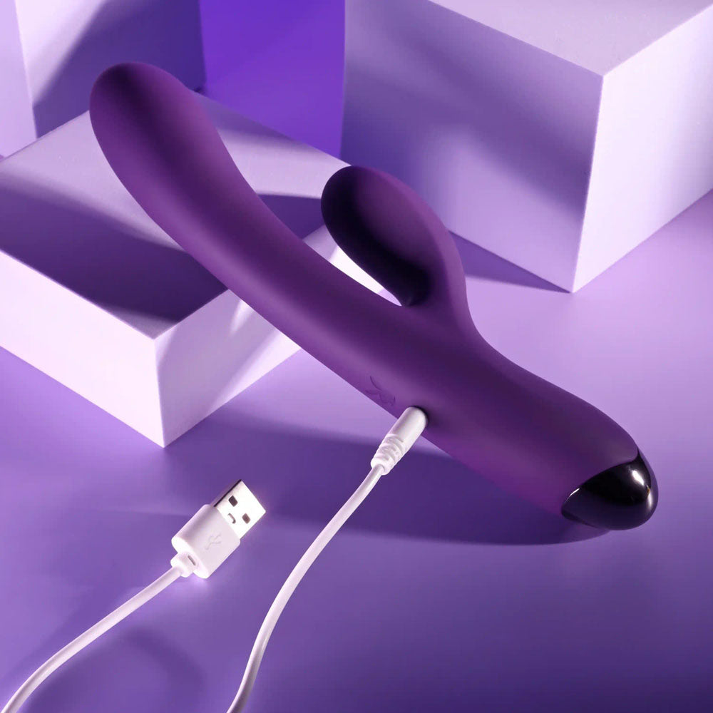 Playboy Pleasure NEW CRUSH - 20.6 cm USB Rechargeable Rabbit Vibrator charging on a purple background.