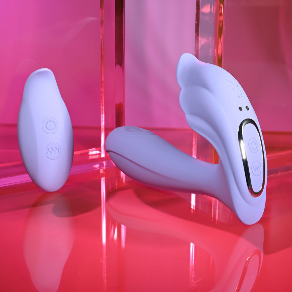 Playboy Pleasure LILAC FANTASY - 13.5 cm USB Rechargeable Tapping Vibrator with Remote on a pink background.