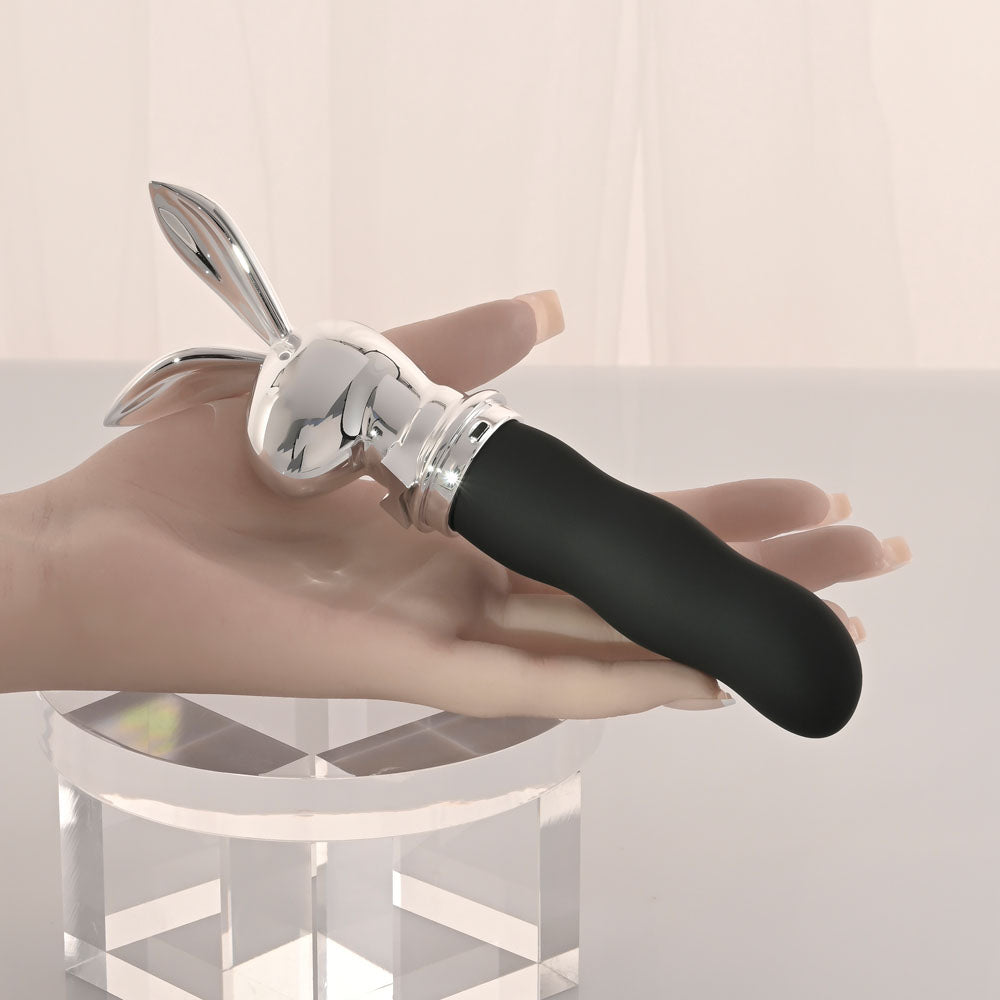 Playboy Pleasure BUNNY ON THE GO - /Chrome 18.6 cm USB-C Rechargeable Vibrator held in a hand, showcasing its sleek design.