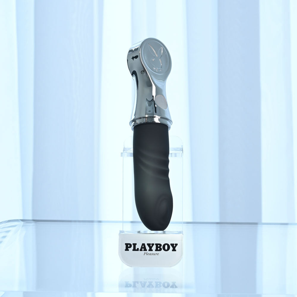 Playboy Pleasure BON VOYAGE - /Chrome 18.7 cm USB-C Rechargeable Tapping Vibrator displayed on a clear stand.