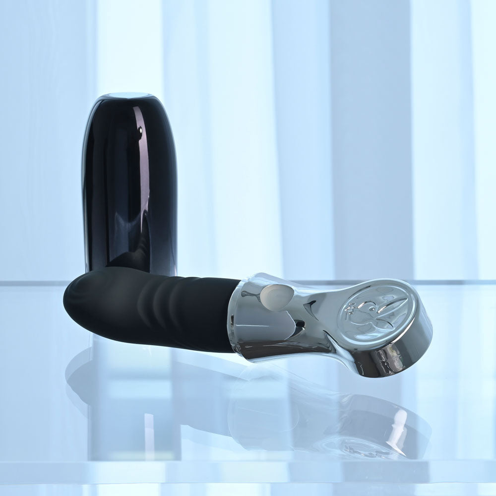 Playboy Pleasure BON VOYAGE - /Chrome 18.7 cm USB-C Rechargeable Tapping Vibrator on a reflective surface.