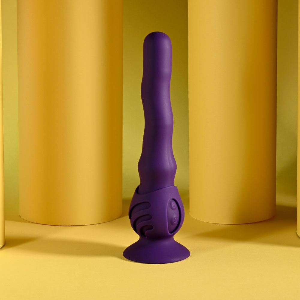 Playboy Pleasure WIGGLE IT - 23.9 cm USB rechargeable wiggling vibrator in purple against a yellow backdrop.