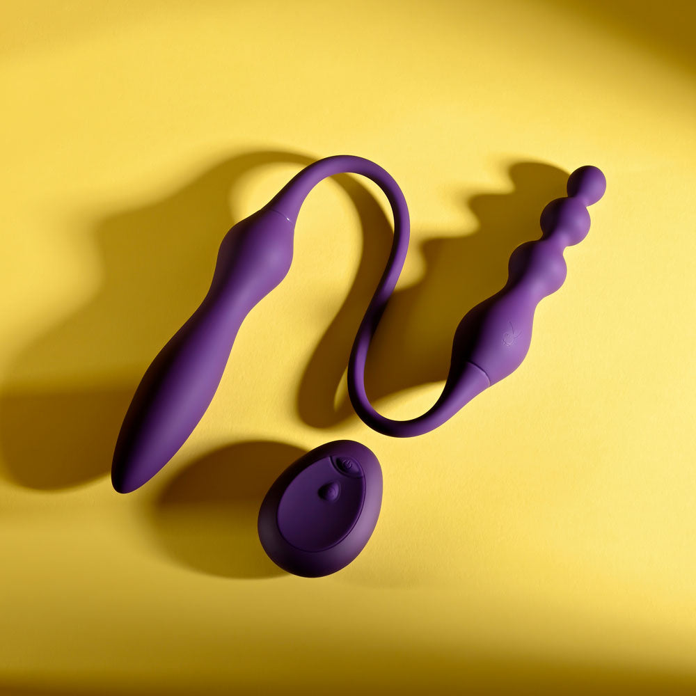 Playboy Pleasure THIS & THAT - 60 cm USB Rechargeable Flexible Dual Ended Vibrator on a yellow background.
